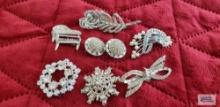 Pale rhinestone clip-on earrings, 3 rhinestone brooches, Pell feather pin, piano rhinestone pin, and